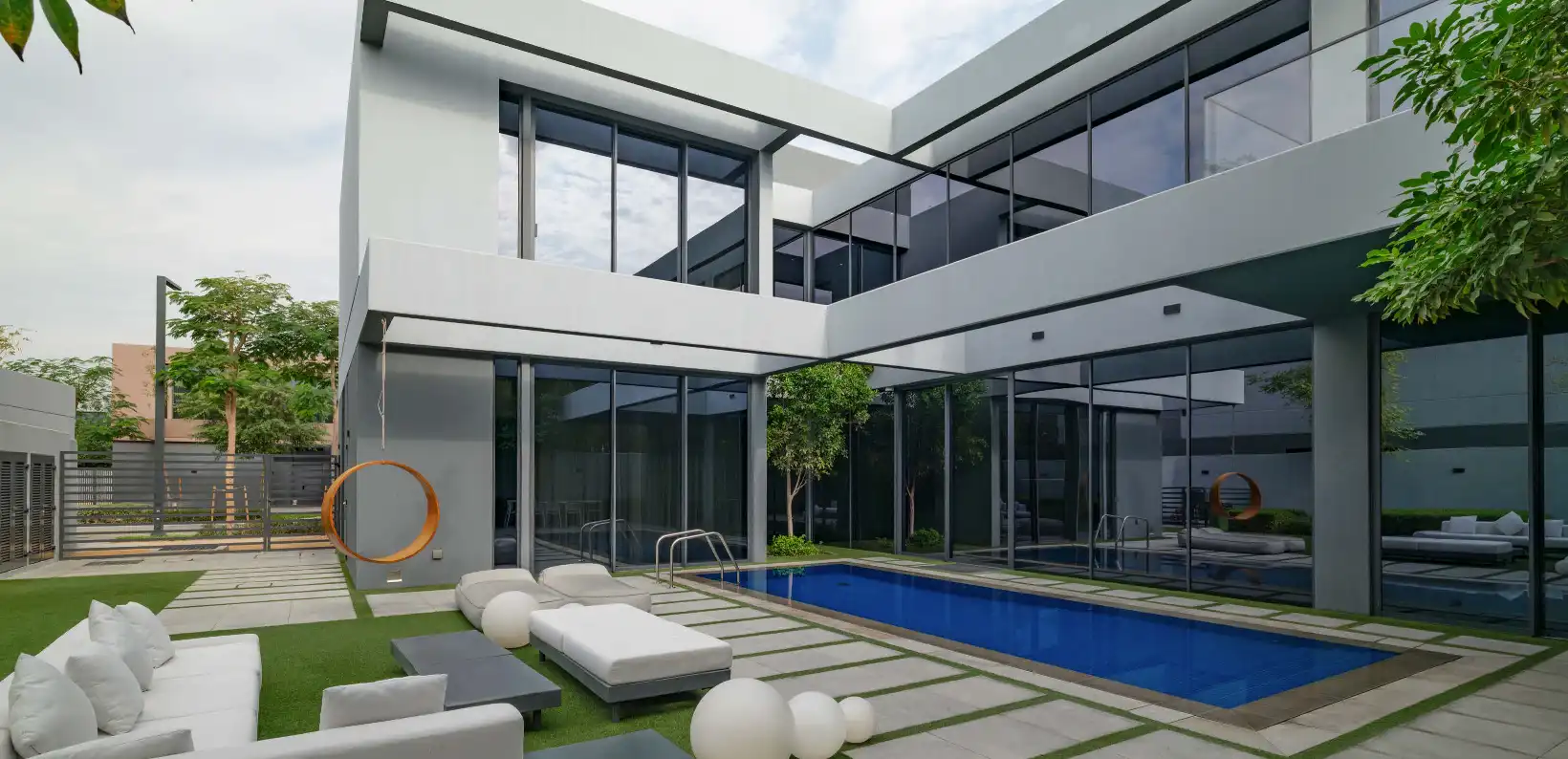 Outdoor swimming pool and villa facade at Anber Masaar